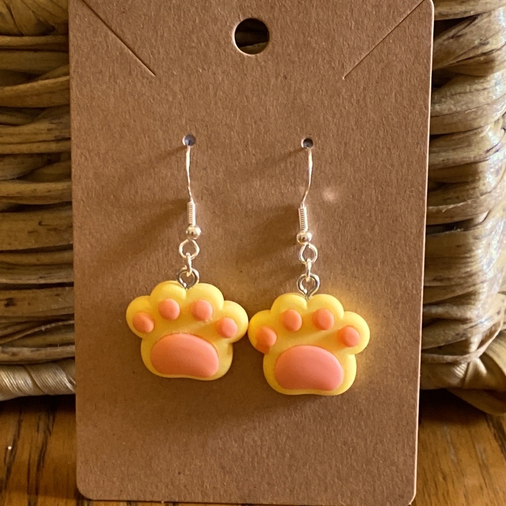 Orange and yellow dog paw earrings with silver wires and random gift bag